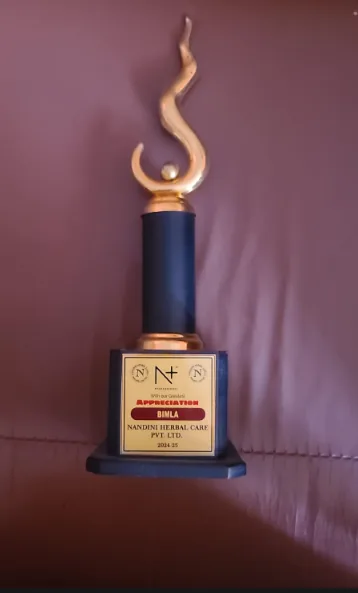 Nandini Herbal Care Pvt Ltd appreciation award trophy given to Bimla, makeup artist