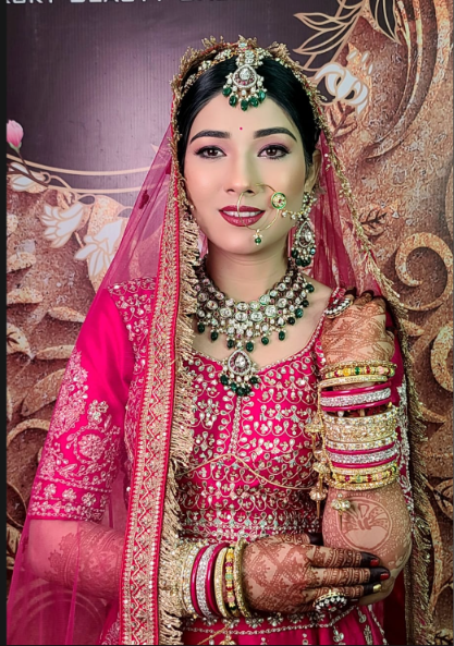 Manasvi bride in pink attire with elegant eye makeup and a smooth bridal base