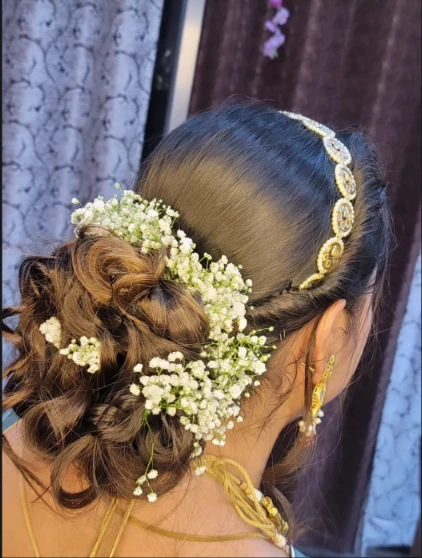 Bridal updo hairstyle with baby's breath flowers by Manasvi